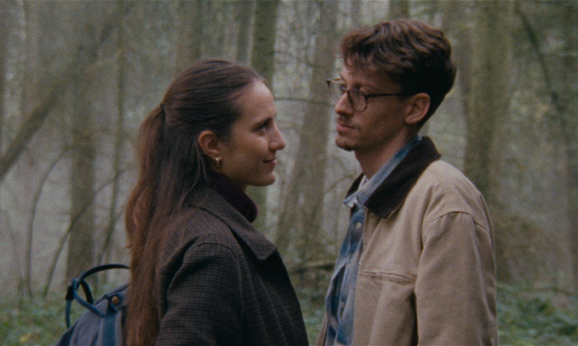 man and woman looking at each other in woods